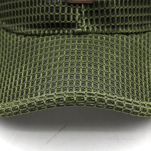 Close-up of army green mesh fabric and brown leather label on a breathable baseball cap