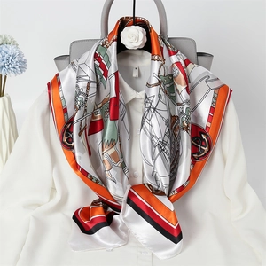 Detail showing a nautical print silk scarf styled on a white shirt and grey handbag