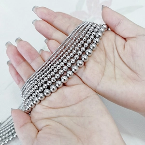 Detail showing multiple sizes of polished stainless steel bead chains held by hand