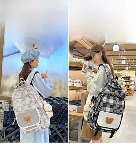 Detail of checkered backpacks with bear patches and plush bunny charms in two colors