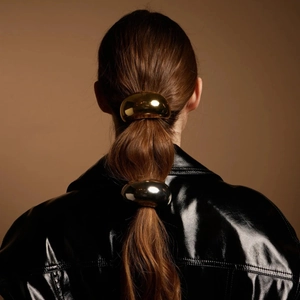 Elastici per capelli in acciaio inossidabile oro e argento lucidi su una modella