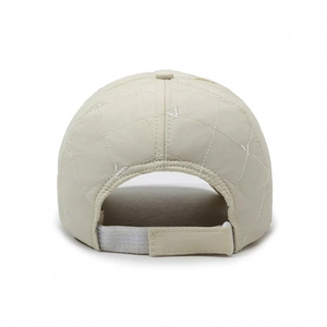 Quilted cream baseball cap with adjustable velcro strap and embroidered detail