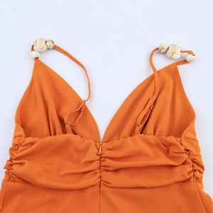 Robe de plage orange avec bretelles perlées, décolleté en V et buste plissé élégant