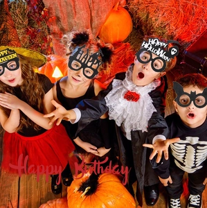 Detail of four colorful Halloween party glasses featuring pumpkin, bat and ghost designs