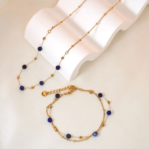 Double-layered gold bracelet and necklace set with faceted dark blue stone beads