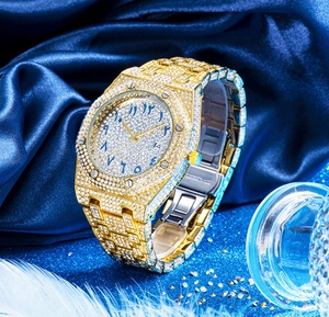 Detail view of luxury iced-out gold watch with crystal dial on blue silk background