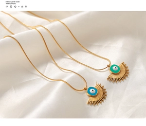 Detail showing gold snake chains with peacock green and royal blue evil eye fan pendants