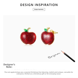 Detailed close-up of red apple stud earrings with gold stem and green leaf detail
