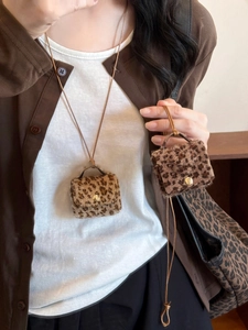 Detail of mini leopard print faux fur pouches used as chic sweater necklace accessories
