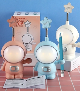 Detail of cute astronaut LED desk lamps with flexible star accents and retail packaging