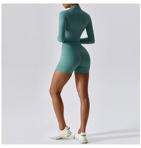 Detail of high-waisted teal green yoga shorts and long sleeve top set for workout