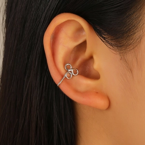 Gros plan d'une manchette d'oreille triple anneaux argentée sur l'oreille du mannequin