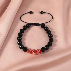 Detail of adjustable beaded bracelet with black and red luminous beads on silk