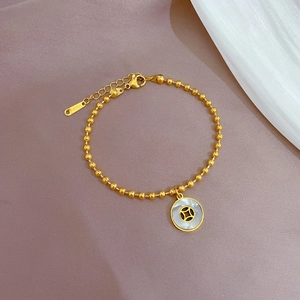 Detail of gold bead bracelet with coin pendant and adjustable stainless steel chain