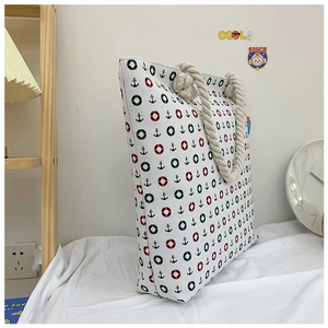 Detail of nautical print canvas tote bag featuring rope handles and anchor patterns