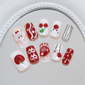 Christmas press-on nails with 3D snowflakes, reindeer, and bow designs in red and white
