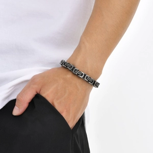 Detailed close-up of a vintage oxidized stainless steel Byzantine chain bracelet on a wrist