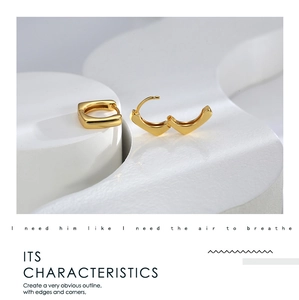 Detail view of gold geometric square earrings with a secure clasp on a minimalist display