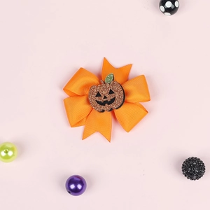 Detailed view of orange glitter pumpkin bow clip with textured grosgrain ribbon