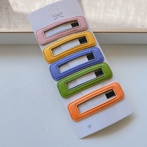 Detailed close-up of 5-piece PU leather hair clips in vibrant candy colors on card