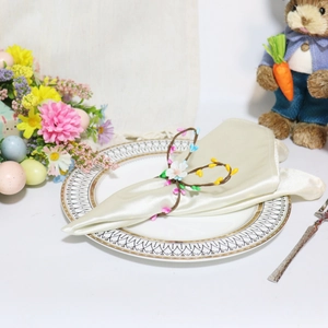 Detail of floral Easter bunny napkin ring with colorful buds on white satin fabric