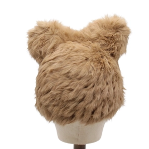 Détail de la texture en fausse fourrure et des oreilles d'ours sur un bonnet d'hiver kaki