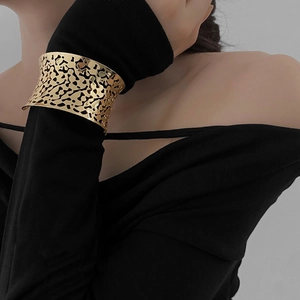 Modern gold hollow cuff bracelet with liquid texture engraving on a model wrist