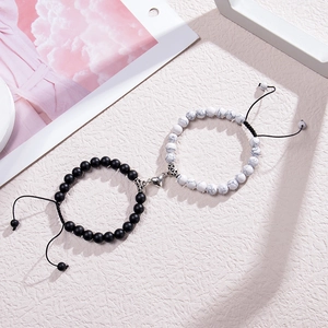 Detail view of magnetic heart charm on adjustable black and white bead bracelets