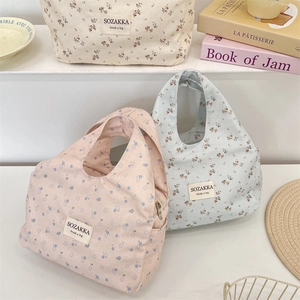 Close-up of floral canvas lunch bags in pink, blue, and white with rustic style