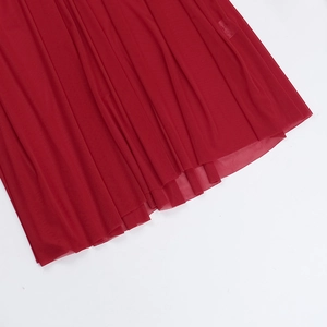 Detail of red mesh dress fabric showing layered tulle texture and elegant drapes