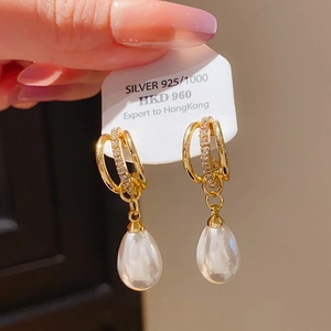 Close-up of gold-plated 925 silver bow drop earrings with pearls and crystals