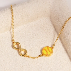 Detailaufnahme eines Unendlichkeitssymbols aus 14k Gold und eines gelben Softball-Anhängers
