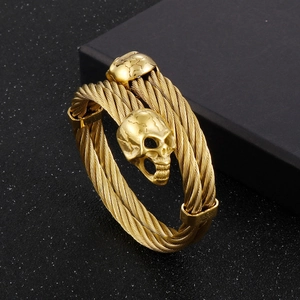 Macro detail of golden double-headed skull cable bracelet in punk gothic steel style
