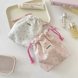 Set of two floral canvas drawstring storage bags in cream and pink with blue flower prints