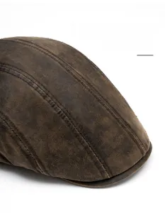 Detail view of brown vintage leather beret cap with stitching and wide foldable brim