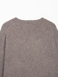 Detail shot of the V-neck brown knit sweater showing ribbed collar and soft wool texture