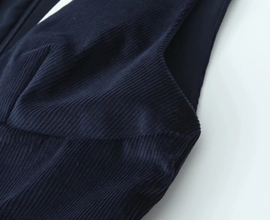 Macro shot of navy blue corduroy fabric showing ribbed texture and stitching detail