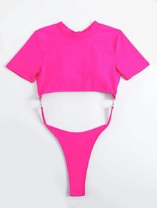 Detailed flat lay of neon pink cut-out swimsuit with silver rings and high-cut thong