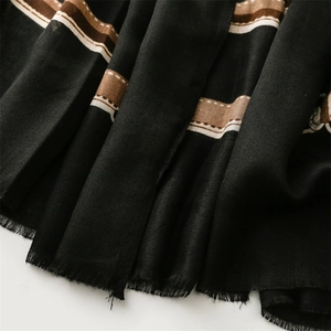 Close-up of black and brown striped cotton linen scarf with soft fringe details