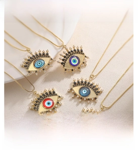Détail des colliers œil porte-bonheur dorés avec zircons colorés et détails de cils