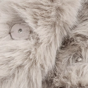 Close-up of soft light grey faux fur texture and hidden snap button closure
