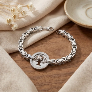 Detailed close-up of tree of life charm with sparkling crystals on a silver chain bracelet