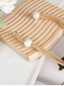Macro view of handmade jute curtain tiebacks with woven rope and elegant white pearls
