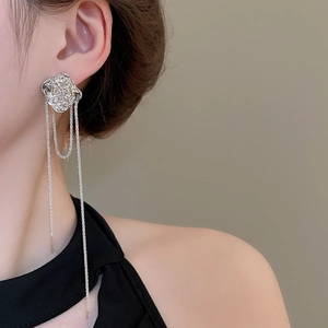 Detailed view of silver flower tassel earrings with long chain fringe worn by model
