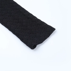 Vue macro du tissu noir texturé montrant un motif ondulé unique et des détails soignés