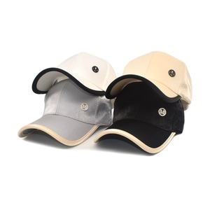Detailed view of satin baseball caps in four colors featuring a metal M logo and contrast brim