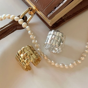 Detail of gold and silver woven texture adjustable rings with polished metallic finish