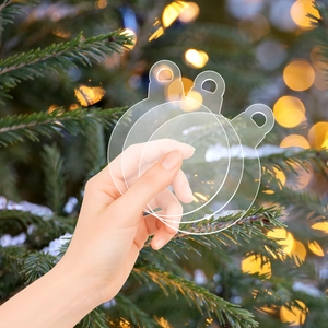 Close-up of clear acrylic Christmas ornaments with hanging hole on a festive tree branch