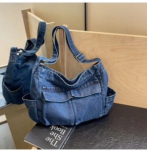 Close-up of deep blue denim crossbody bag featuring utility pockets and adjustable strap