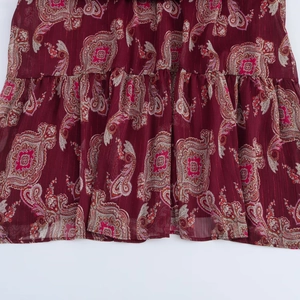 Détail d'une robe longue cachemire bordeaux avec fils de soie métalliques verticaux